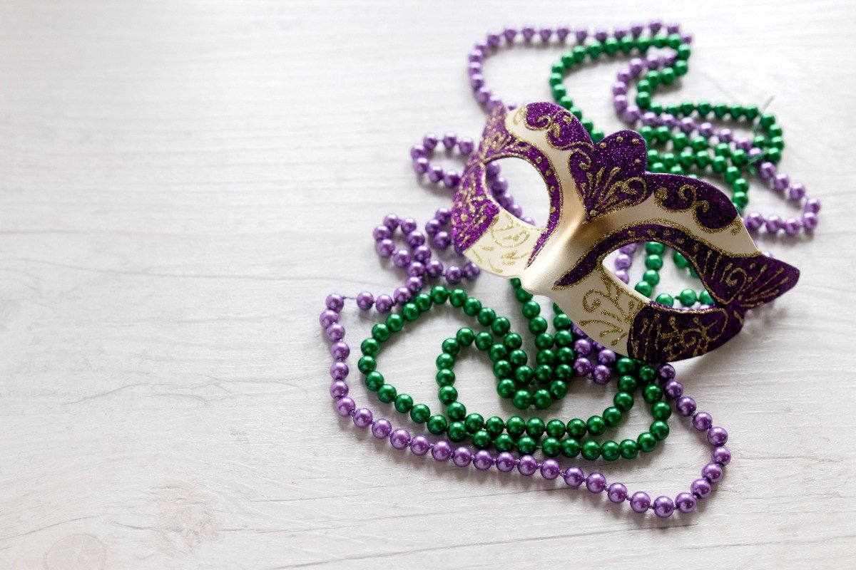Mardi Gras Mask and beads laying on a table